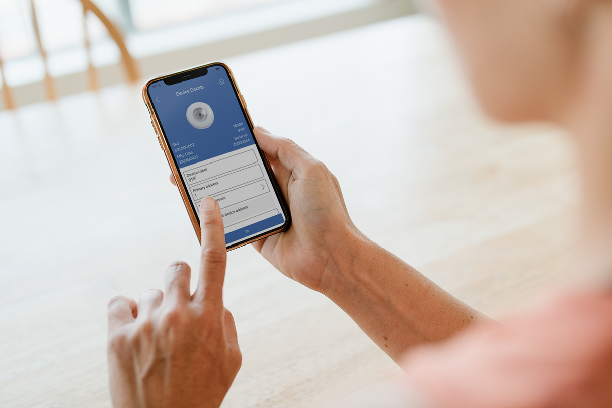 A person looking at a mobile screen displaying details of a fire detection unit