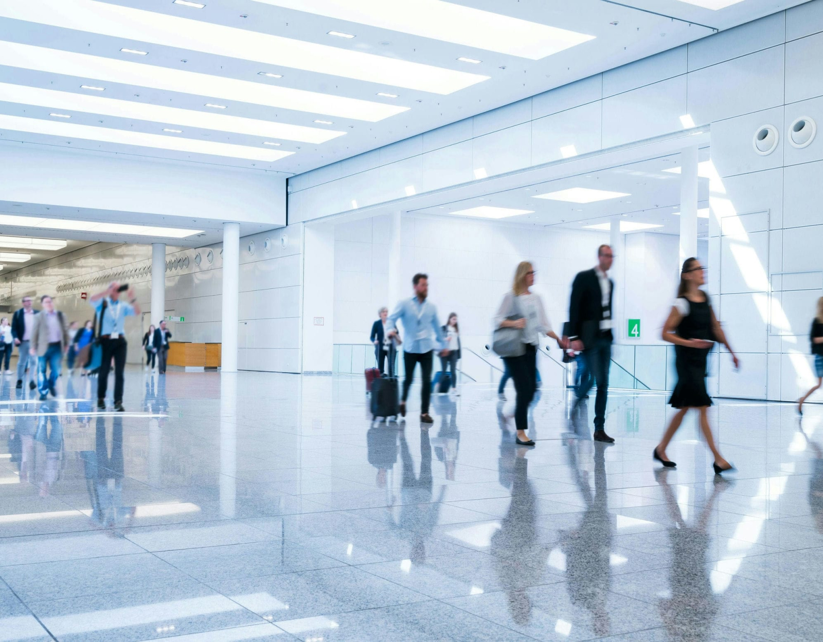 People walking with suitcases along a passageway